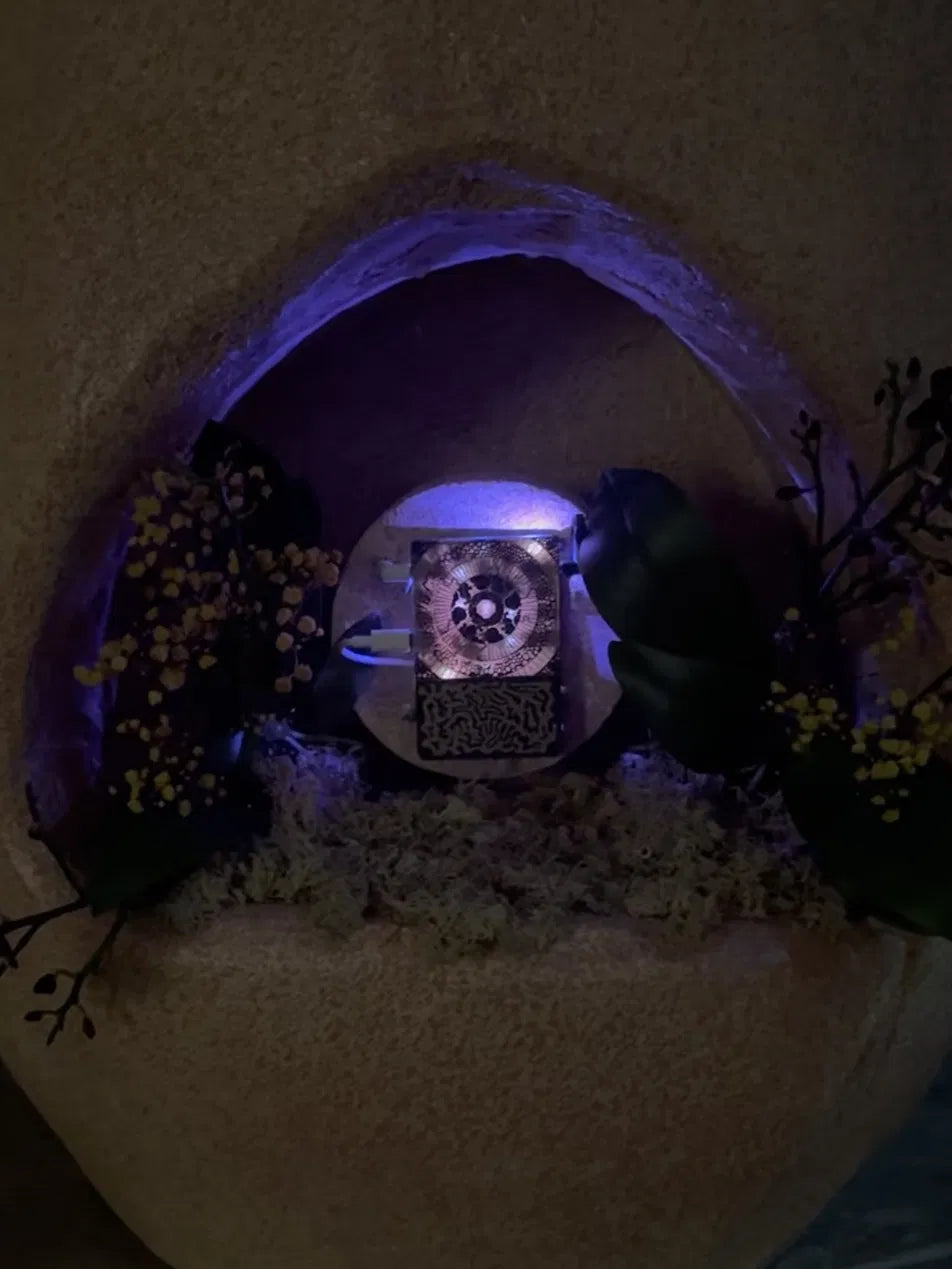 A biofeedback instrument lit inside a sculpture niche